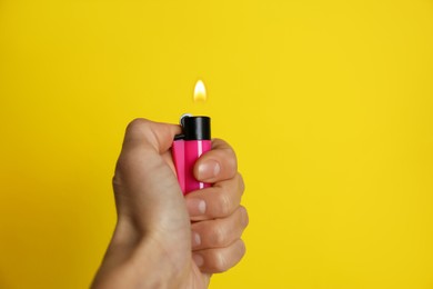 Photo of Woman holding pink lighter on yellow background, closeup. Space for text