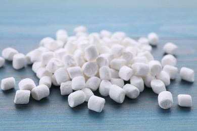 Photo of Delicious marshmallows on light blue wooden table, closeup