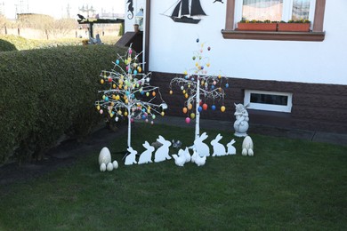 Photo of Trees with decorative eggs, chickens and bunnies at backyard. Easter celebration