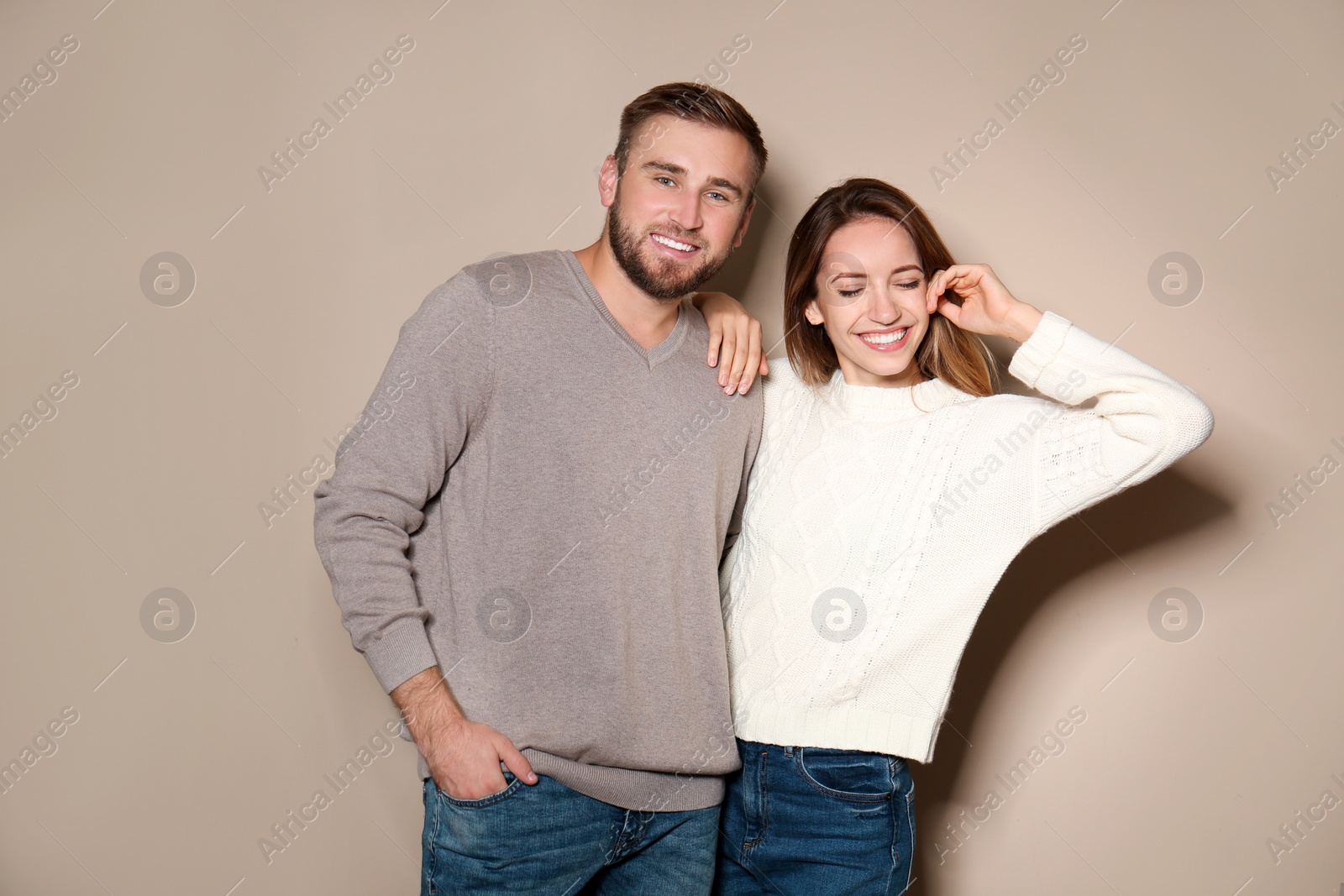 Image of Lovely couple in warm sweaters on beige background