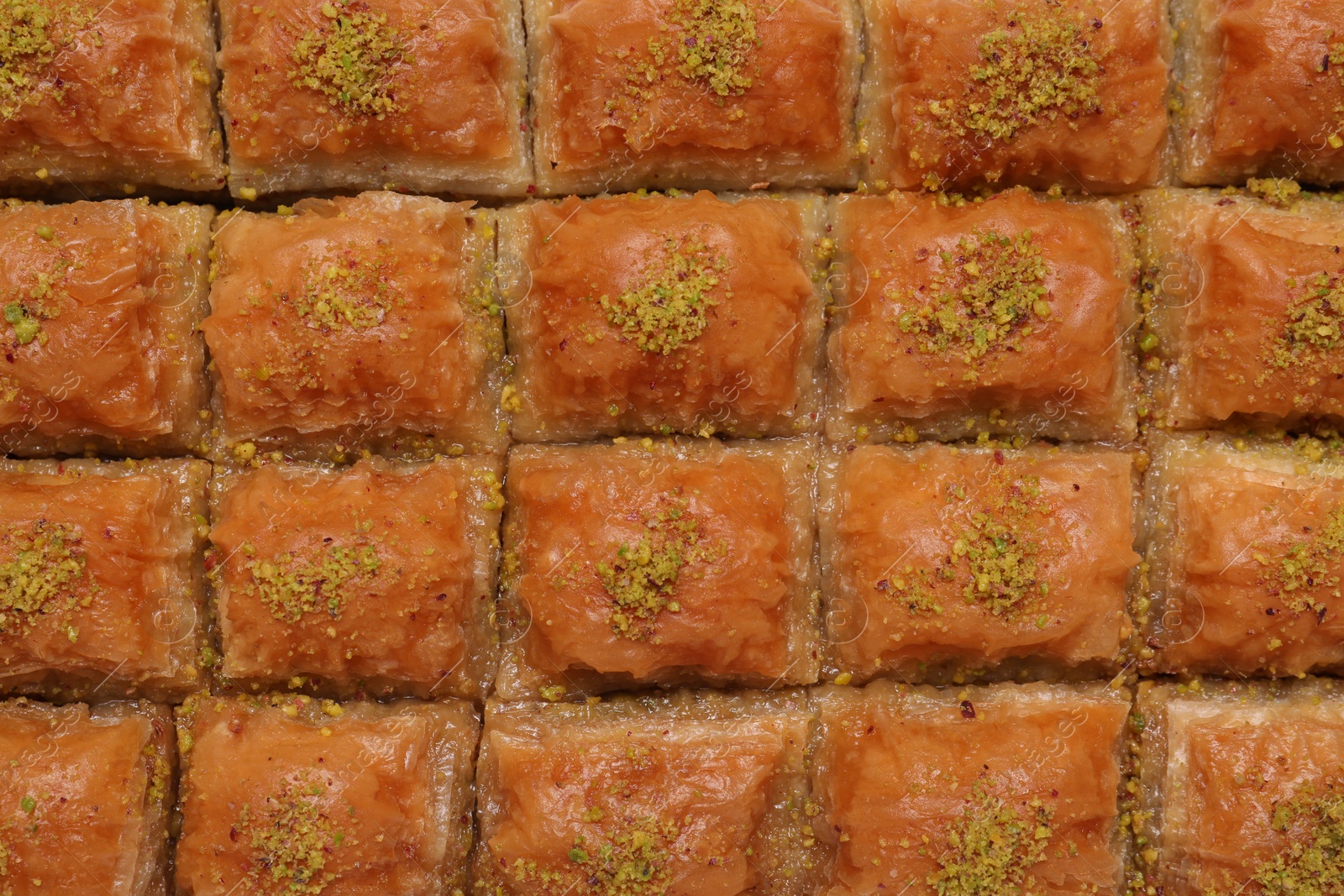 Photo of Delicious sweet baklava with pistachios as background, top view