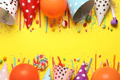 Photo of Flat lay composition with party decor and candies on yellow background, space for text