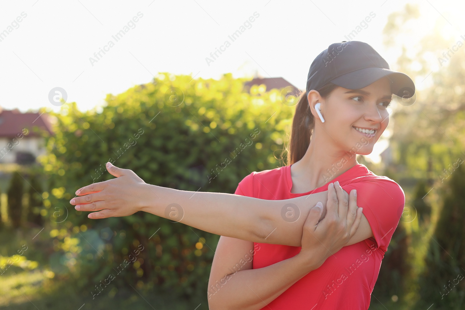 Photo of Young woman listening to music while doing morning exercise in park