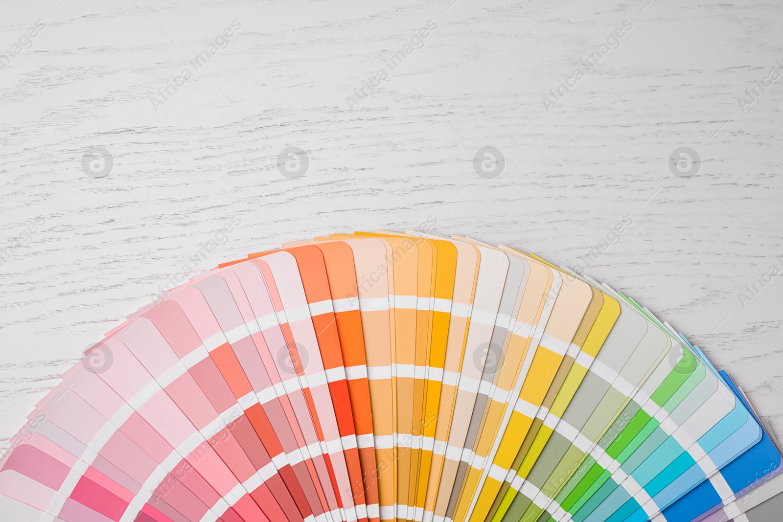 Photo of Bright palette sample and space for text on white wooden table, flat lay. Rainbow colors