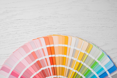 Bright palette sample and space for text on white wooden table, flat lay. Rainbow colors