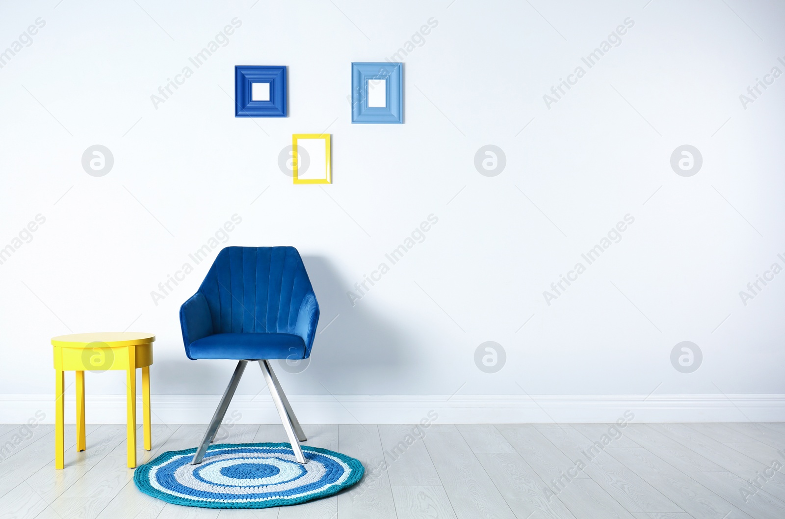 Photo of Stylish room interior with chair and side table near white wall, space for text