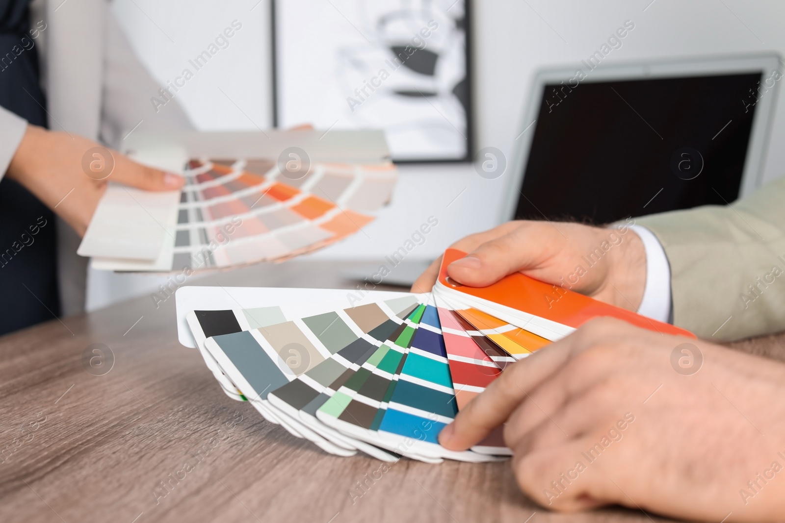 Photo of Team of designers working with color palettes at office table, closeup