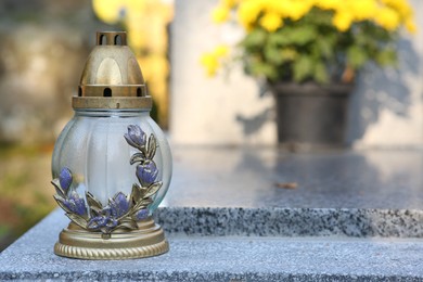 Photo of Grave lantern on granite surface in cemetery, space for text