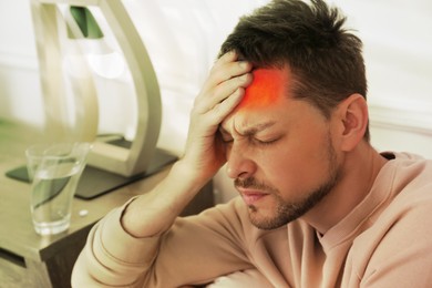 Man suffering from terrible migraine at home