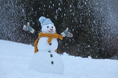 Adorable smiling snowman outdoors on winter day. Space for text