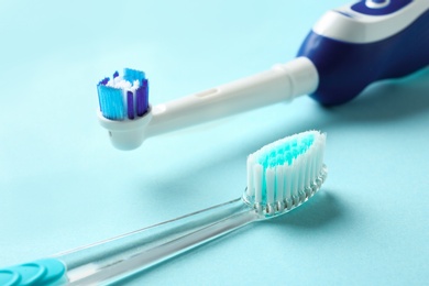 Photo of Manual and electric toothbrushes on color background. Dental care