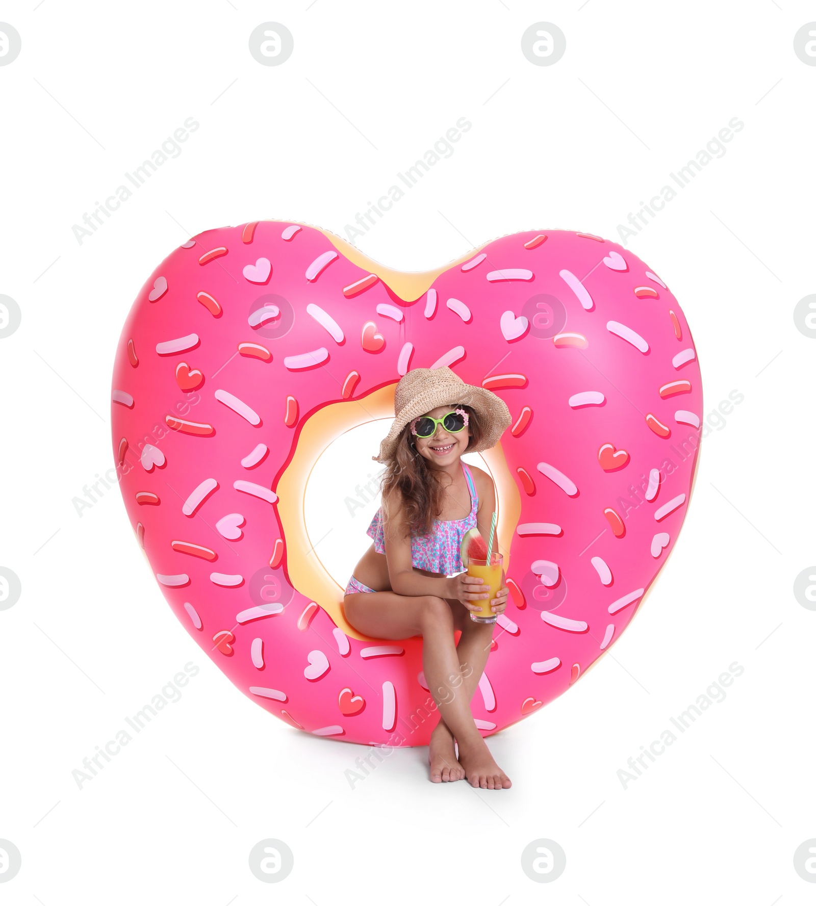 Photo of Cute little girl with inflatable heart and glass of cocktail on white background