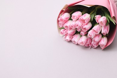 Photo of Beautiful bouquet of fresh pink tulips on light background. Space for text