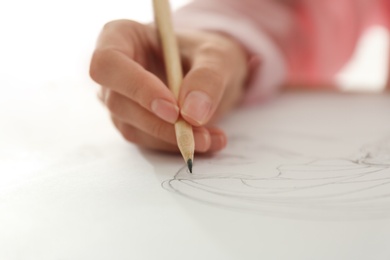 Photo of Woman drawing girl's portrait with pencil on sheet of paper, closeup