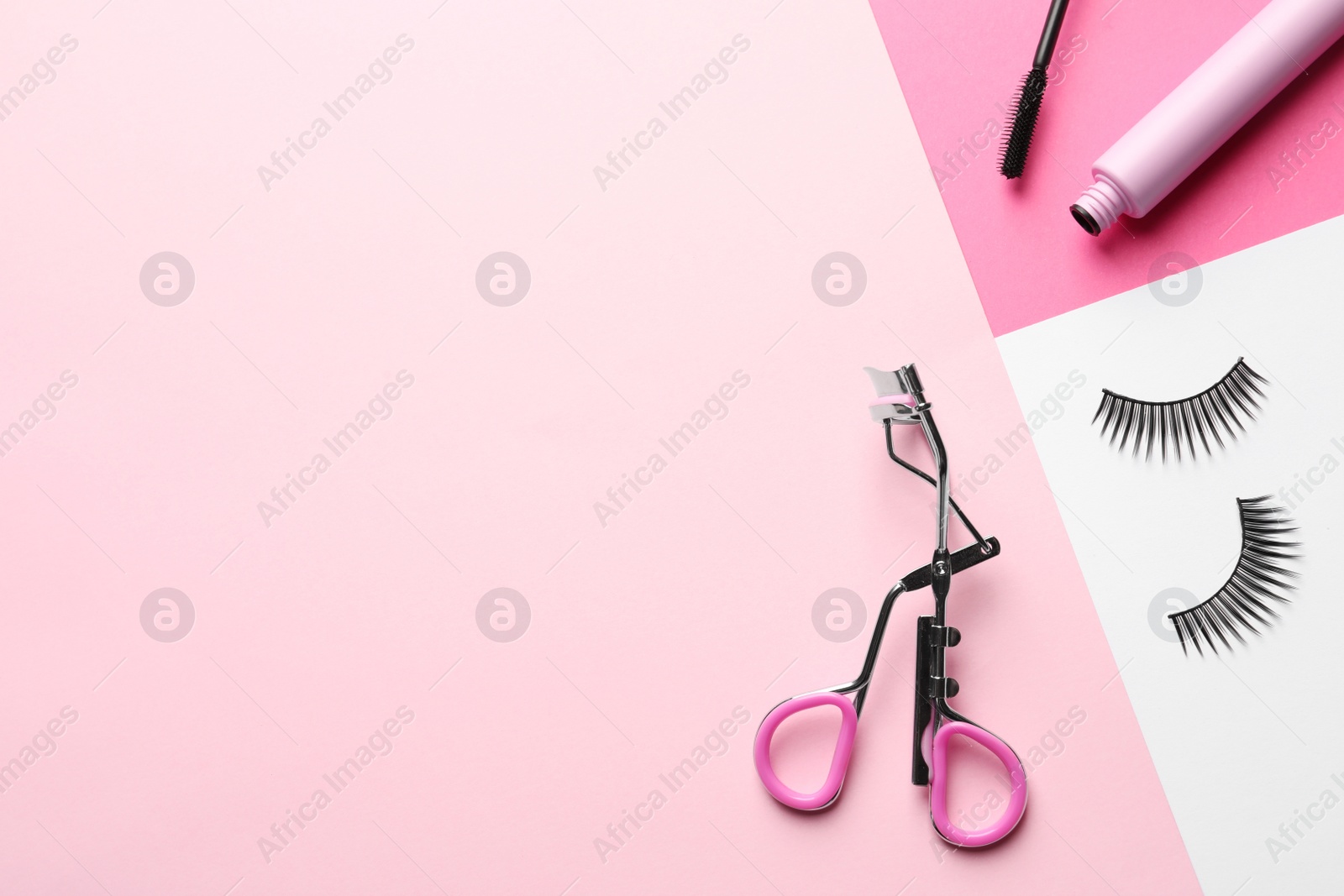 Photo of False eyelashes, curler and mascara on color background, flat lay. Space for text