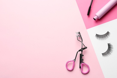Photo of False eyelashes, curler and mascara on color background, flat lay. Space for text