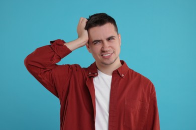 Photo of Portrait of embarrassed young man on light blue background