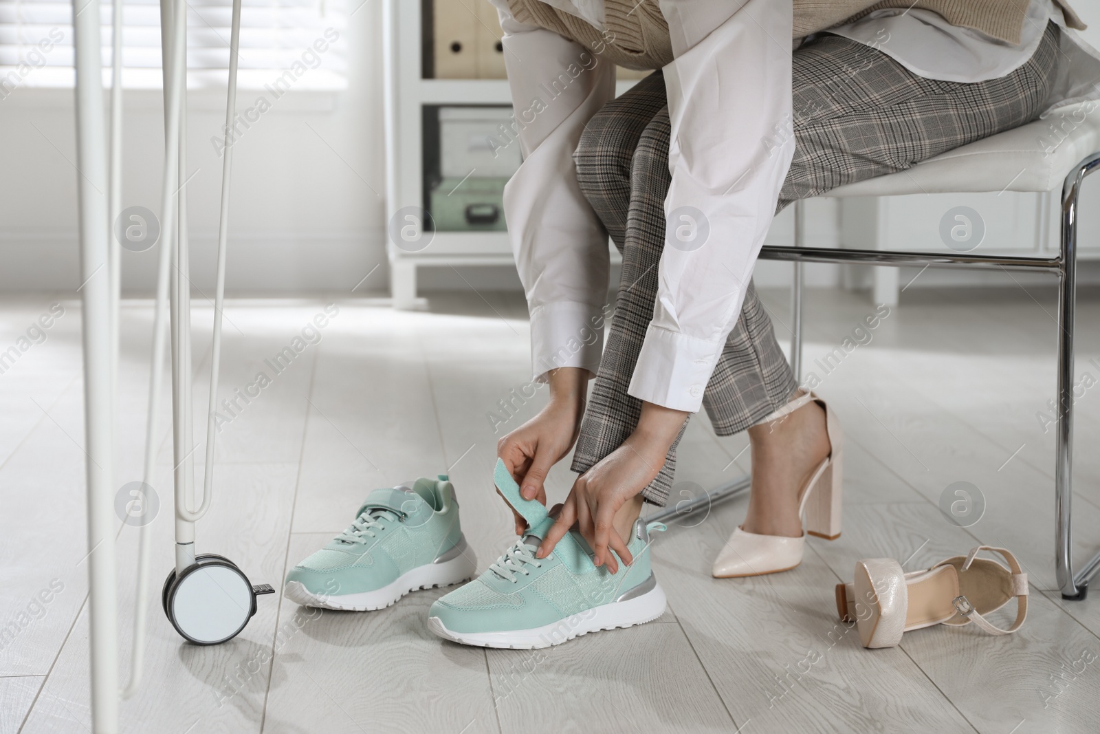 Photo of Woman changing shoes at workplace in office, closeup