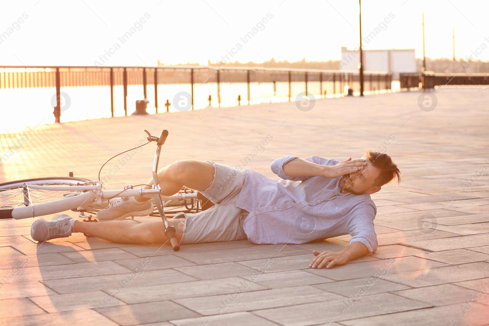 Photo of Man fallen off his bicycle on street