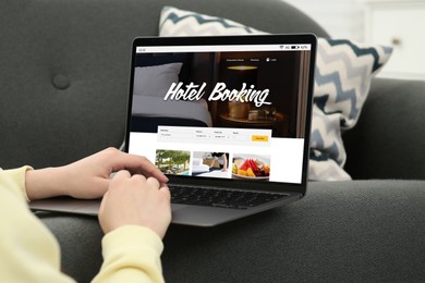 Image of Woman using laptop to book hotel at home, closeup