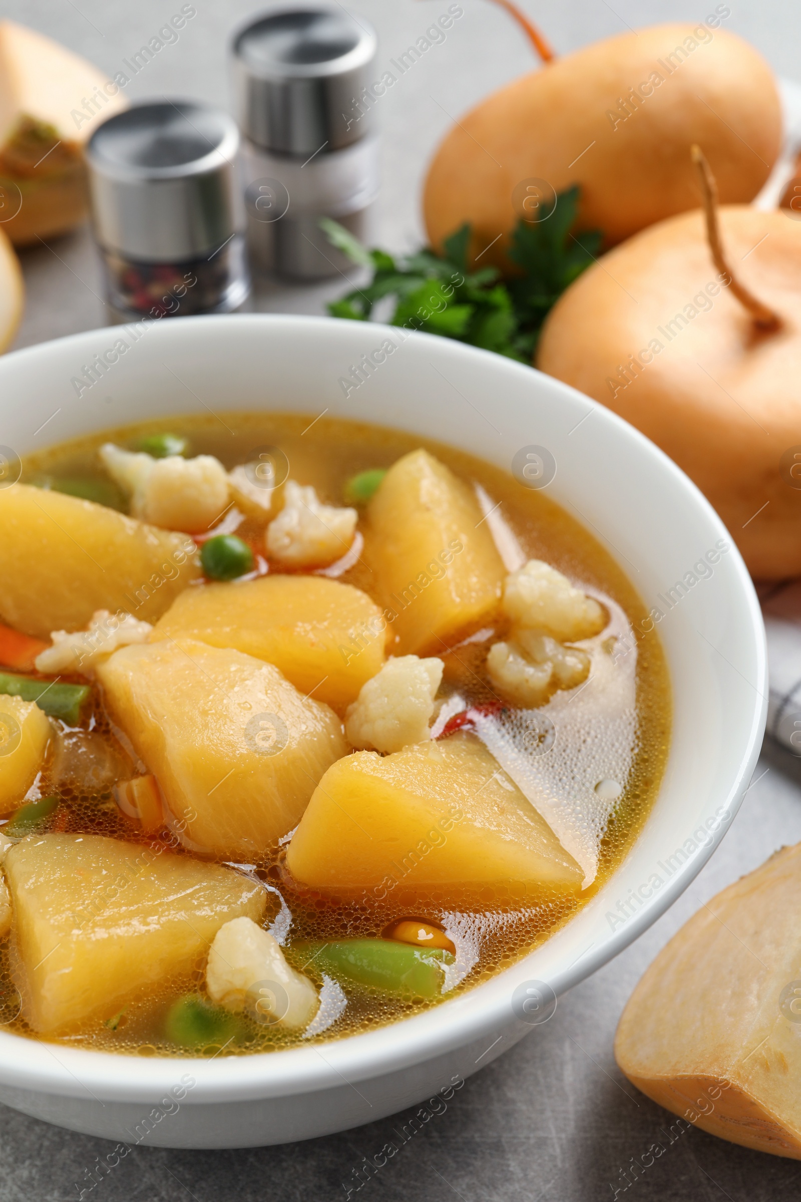 Photo of Bowl of delicious turnip soup on table