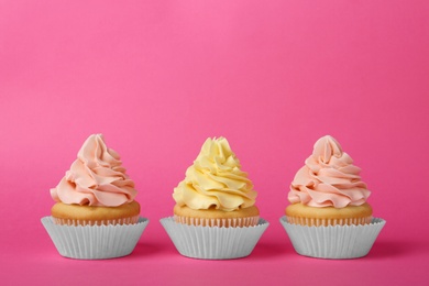 Photo of Tasty cupcakes with cream on pink background