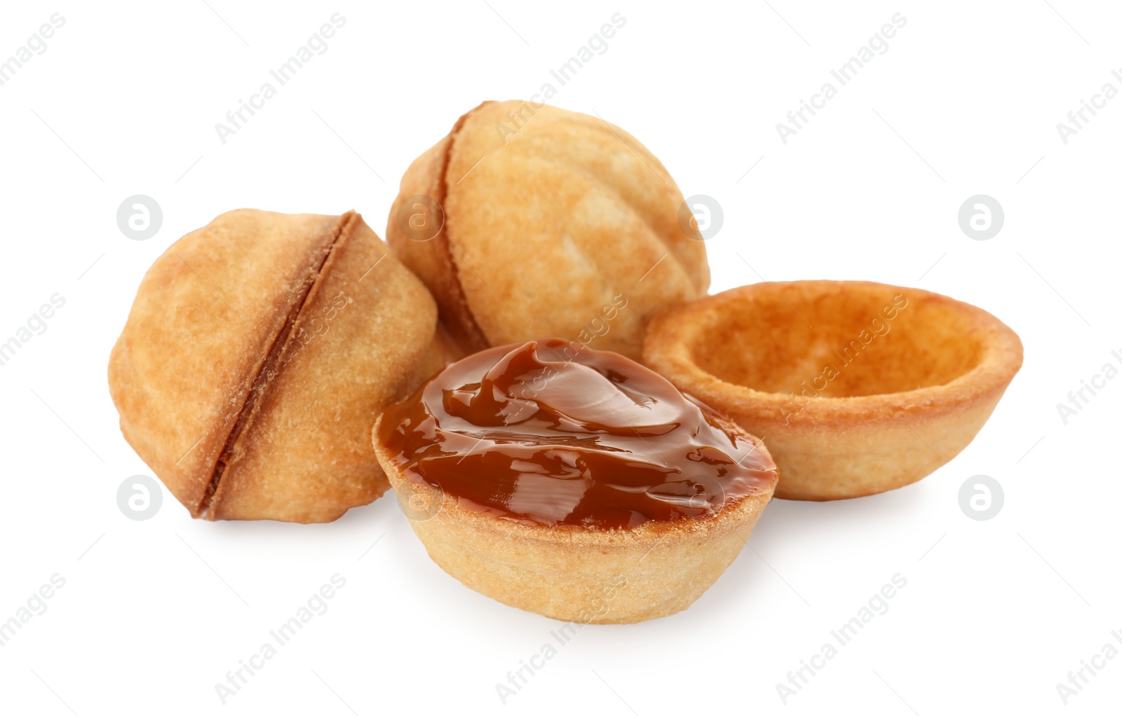 Photo of Delicious nut shaped cookies with boiled condensed milk on white background