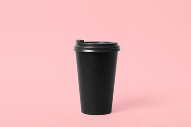 Takeaway paper coffee cup on pink background