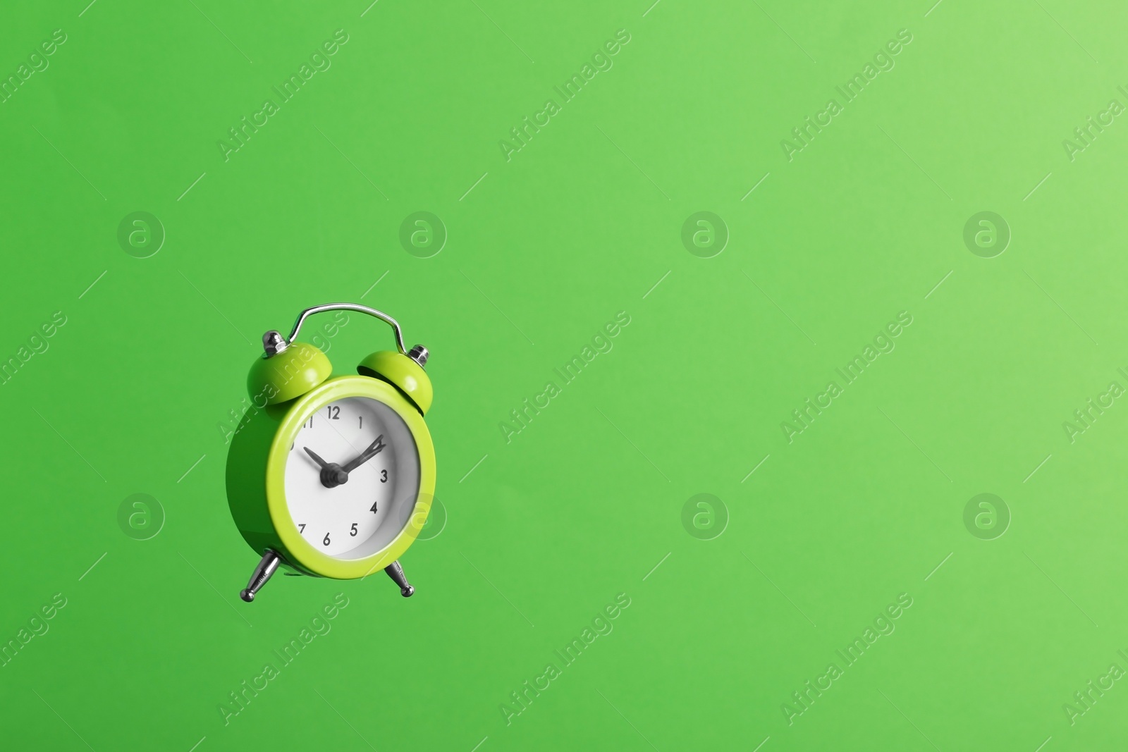 Photo of Alarm clock on green background. Space for text