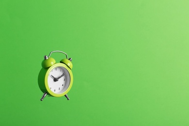 Alarm clock on green background. Space for text