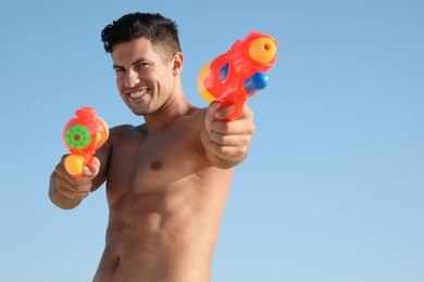 Photo of Man with water guns against blue sky