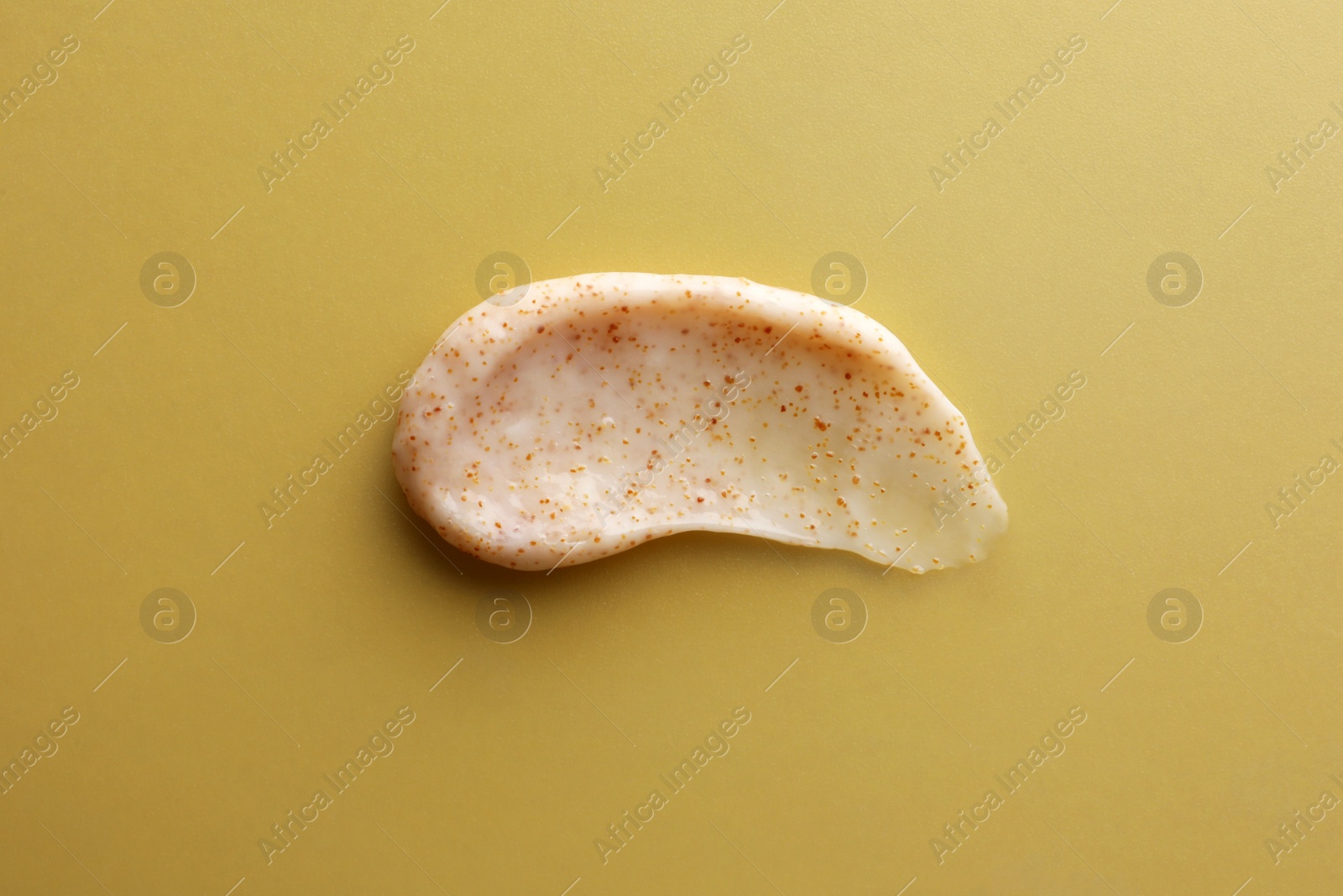 Photo of Sample of natural scrub on dark yellow, top view