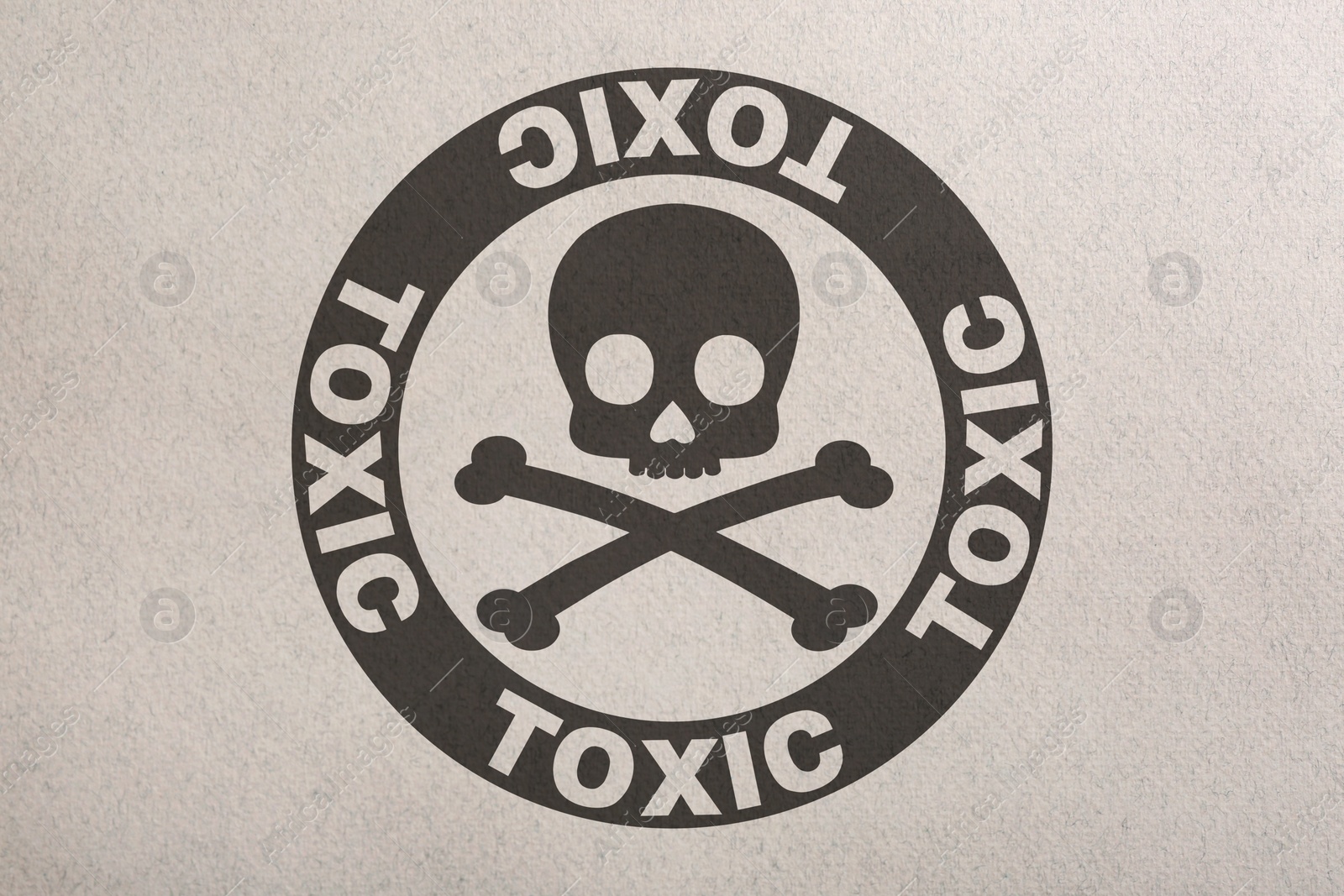 Image of Hazard warning sign (skull-and-crossbones symbol and word TOXIC) on paper, top view