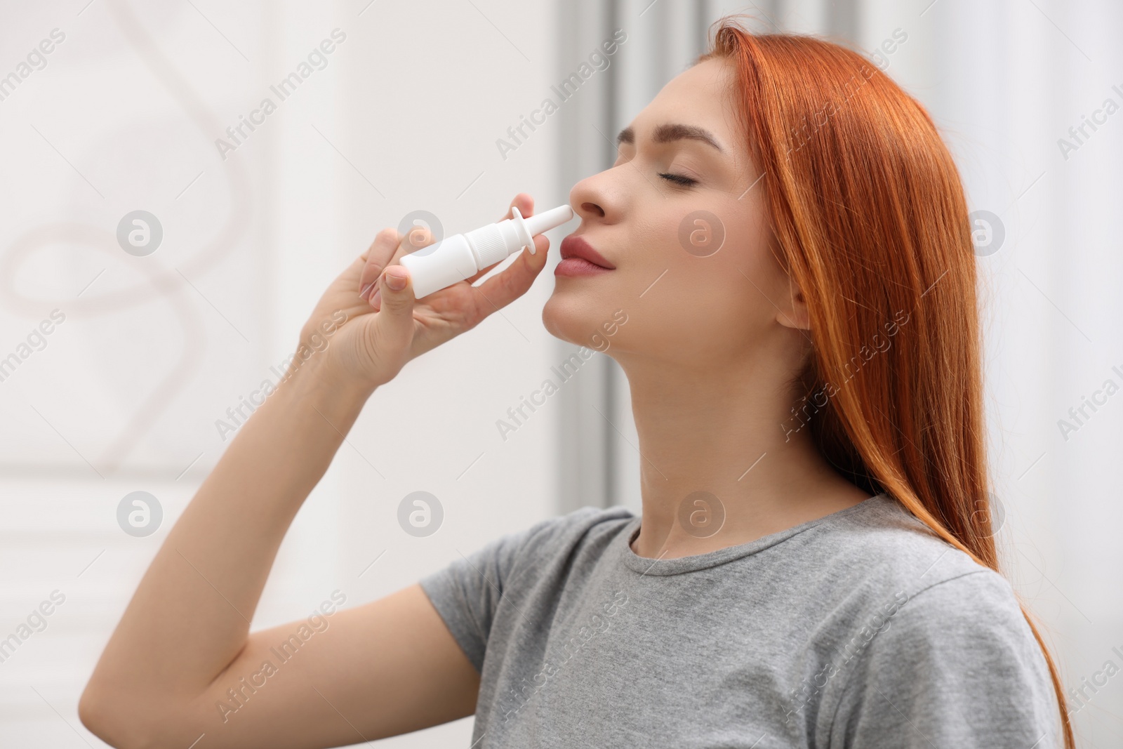 Photo of Medical drops. Woman using nasal spray at home