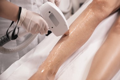 Photo of Woman undergoing laser epilation procedure in beauty salon, closeup