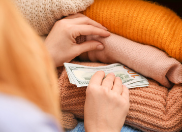 Photo of Woman hiding money between clothes, closeup. Financial savings