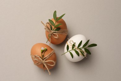 Chicken eggs and natural decor on light grey background, flat lay. Happy Easter