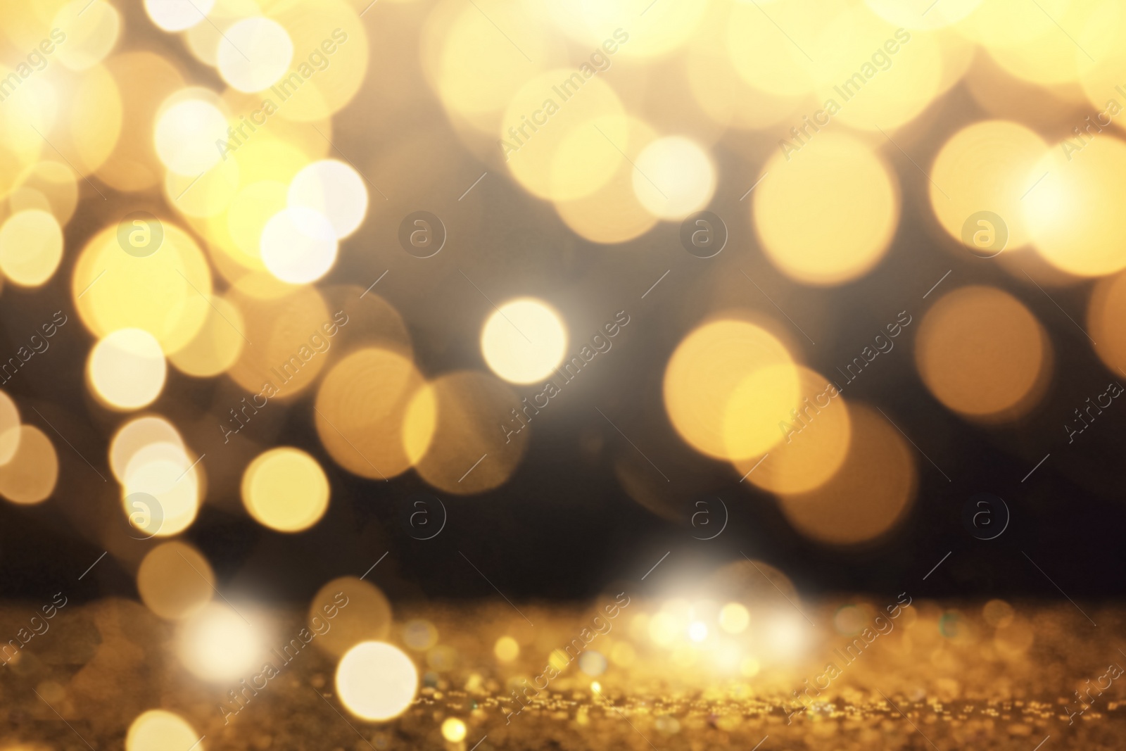 Image of Blurred view of gold glitter on dark background, bokeh effect