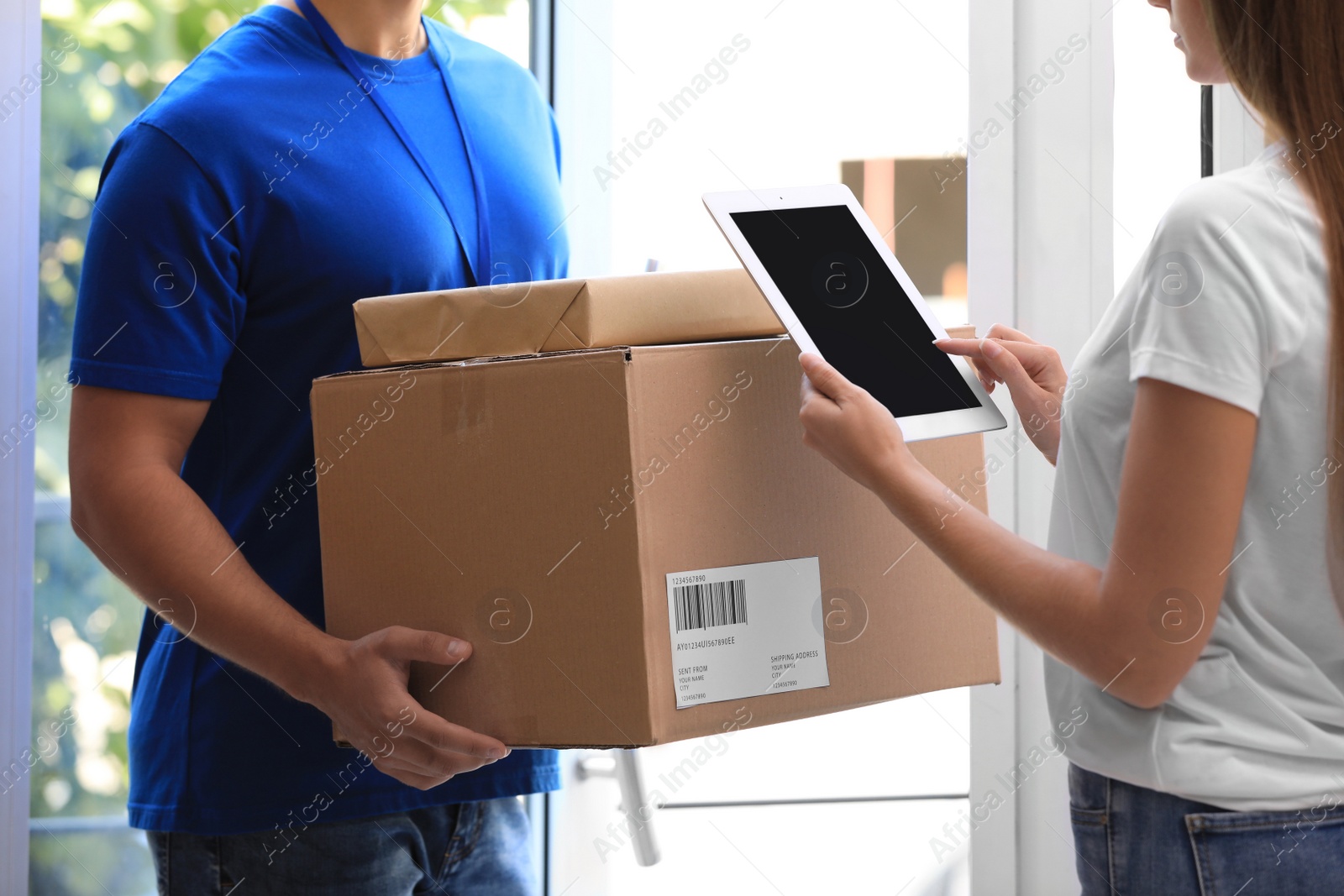 Photo of Woman using app to confirm delivery of parcels from courier on doorstep, closeup