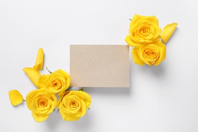 Photo of Beautiful yellow roses and blank card on white background, flat lay. Space for text