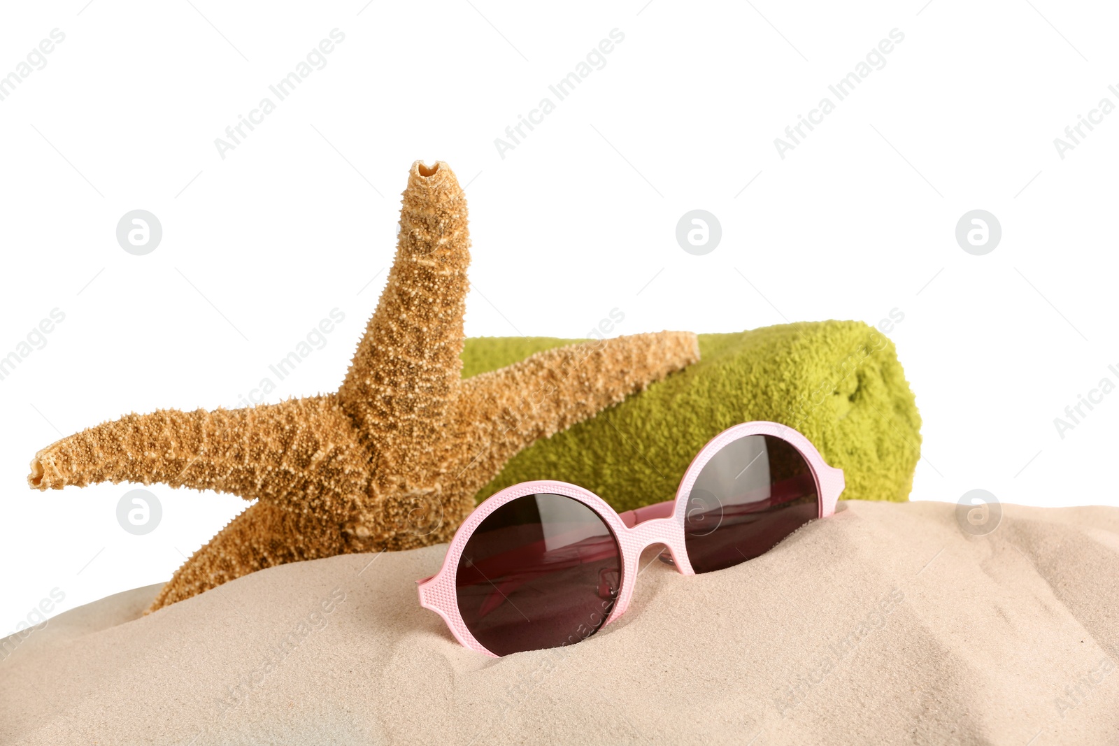 Photo of Beach accessories on sand against white background