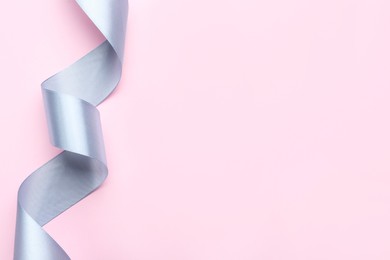 Beautiful ribbon on pink background, top view. Space for text