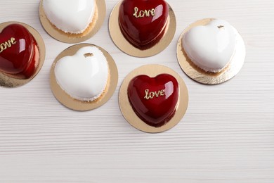 Photo of St. Valentine's Day. Delicious heart shaped cakes on white wooden table, flat lay