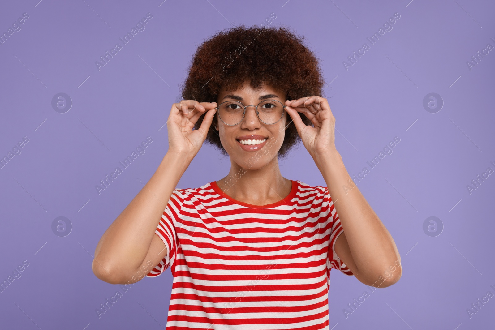 Photo of Portrait of happy young woman in eyeglasses on purple background