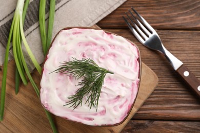 Herring under fur coat on wooden table, flat lay. Traditional Russian salad