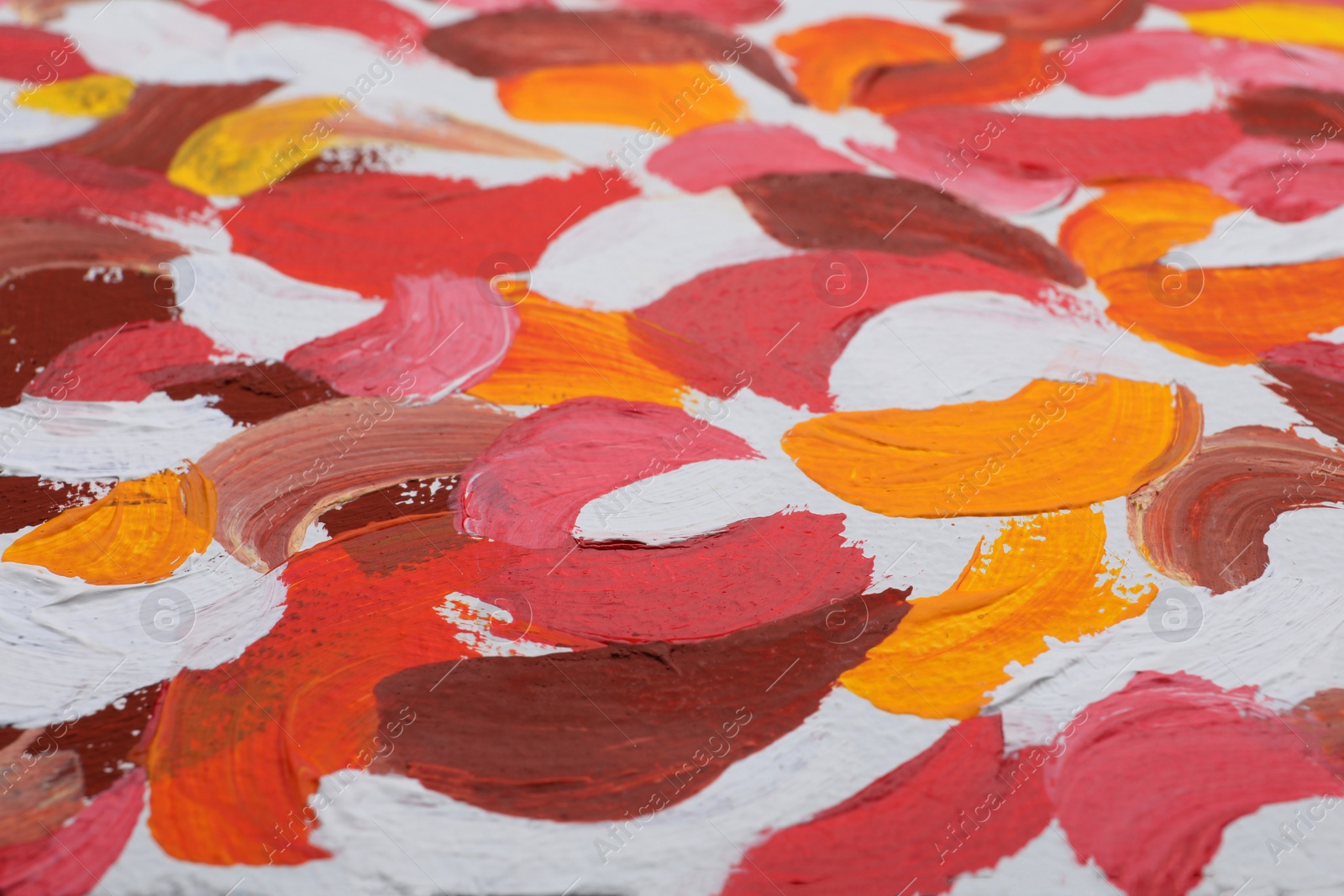 Photo of Beautiful strokes of bright oil paints on white canvas as background, closeup