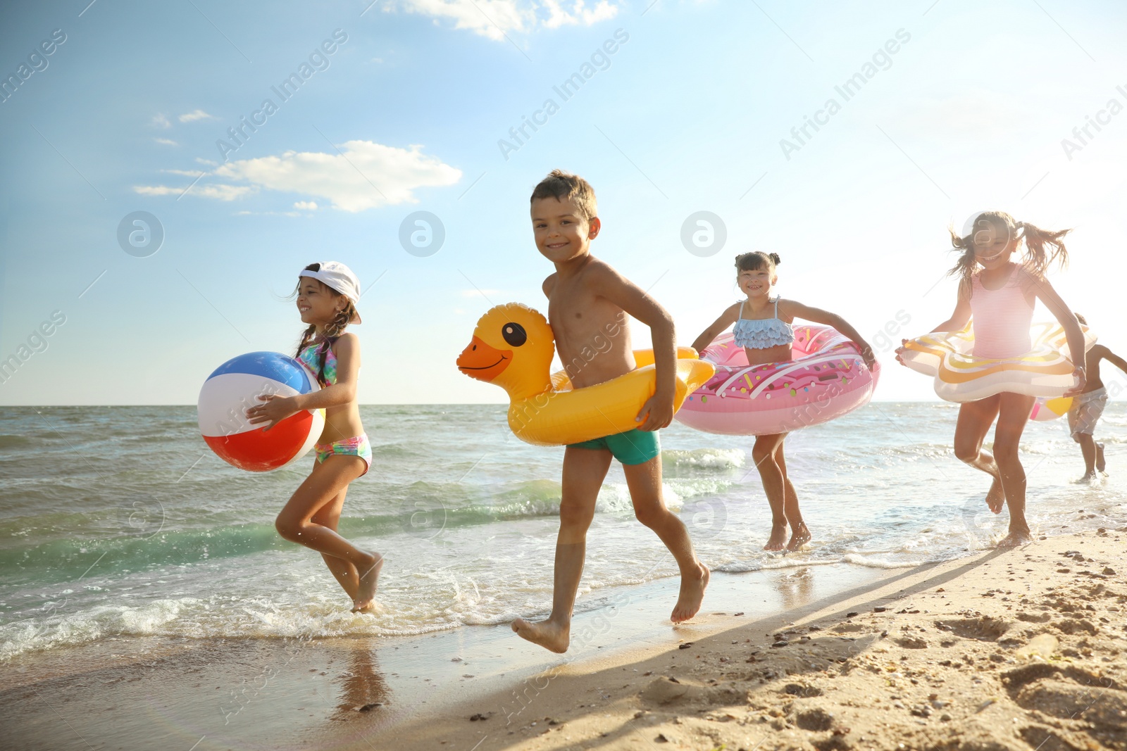 Photo of Cute children enjoying sunny day at beach. Summer camp