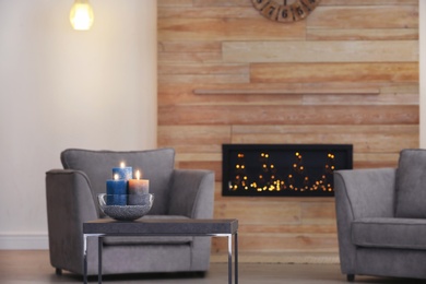 Room interior with armchairs and burning candles on table