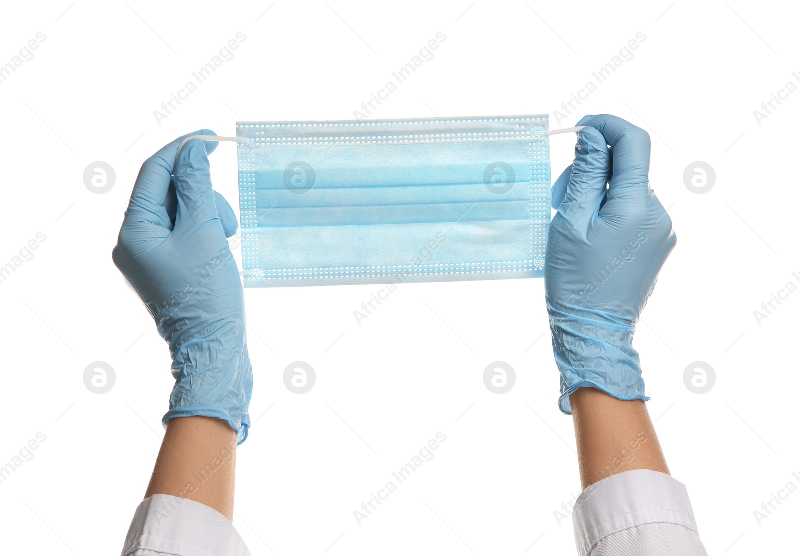 Photo of Doctor in latex gloves holding disposable face mask on white background, closeup. Protective measures during coronavirus quarantine