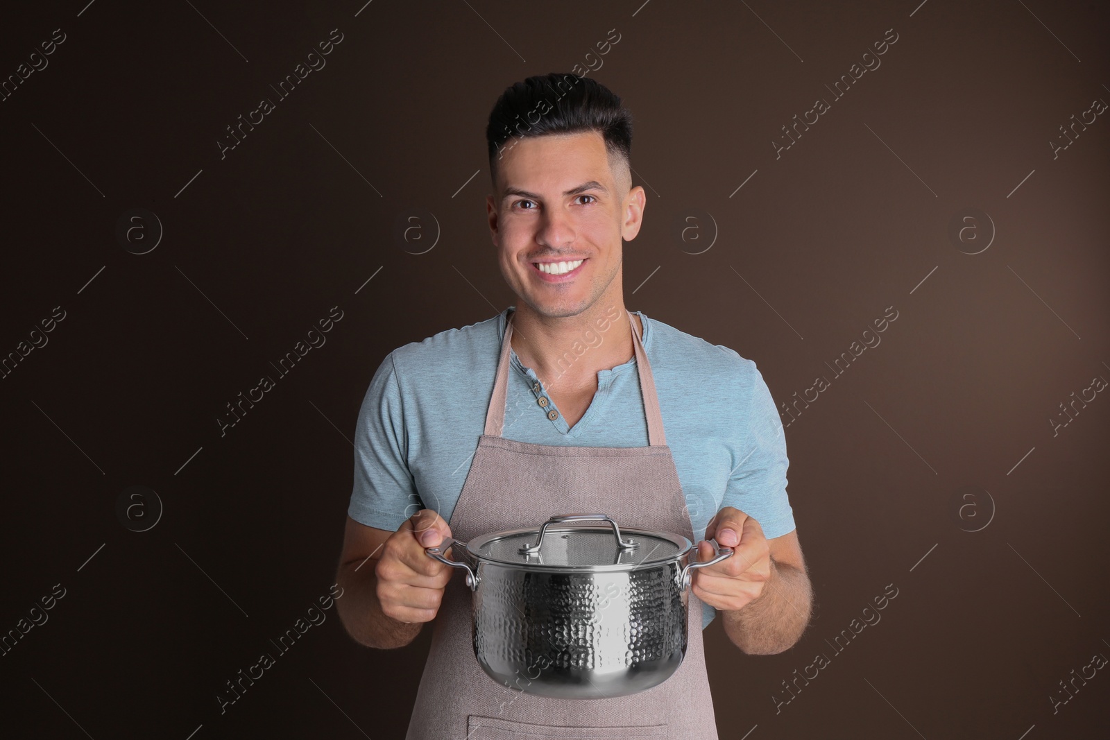 Photo of Happy man with pot on brown background